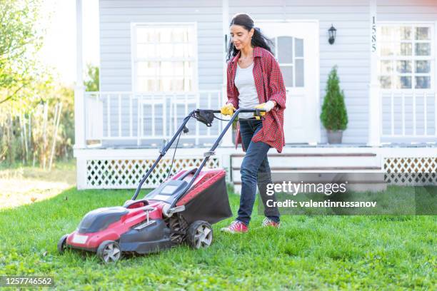mid women using a lawn mower in her backyard - mowing stock pictures, royalty-free photos & images