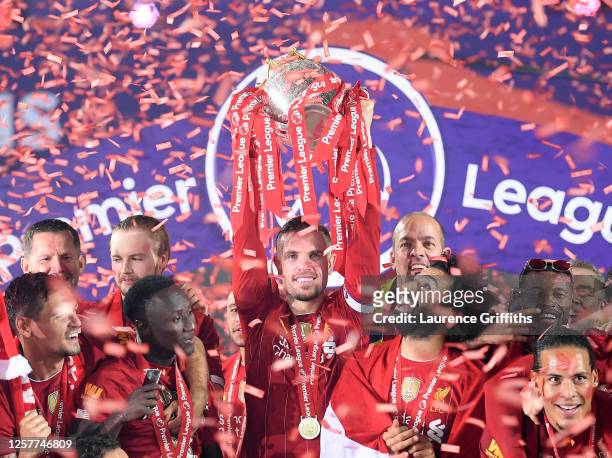 Jordan Henderson of Liverpool holds the Premier League Trophy aloft along side Mohamed Salah as they celebrate winning the League during the...