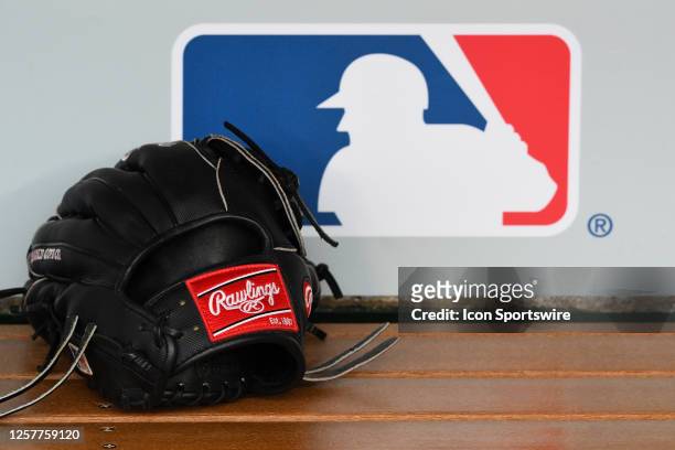 Rawlings glove in the dugout with the MLB logo behind it before the MLB game between the Boston Red Sox and the Los Angeles Angels of Anaheim on May...