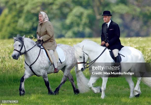 Queen Elizabeth II, accompanied by her Stud Groom Terry Pendry, seen horse riding in the grounds of Windsor Castle on June 2, 2006 in Windsor,...