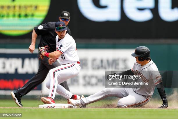 Wilmer Flores of the San Francisco Giants is safe at second base on his double as Edouard Julien of the Minnesota Twins fields the ball in the ninth...