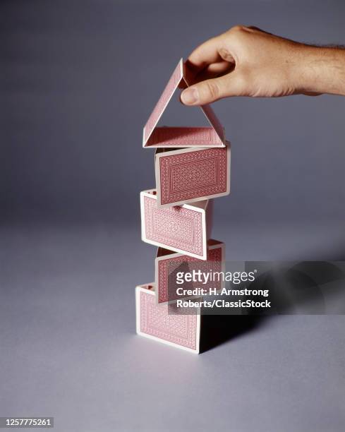 2000s Human Hand Building Towering House Of Playing Cards Architecture Stability Dependent Or Relying On Balance And Or Friction