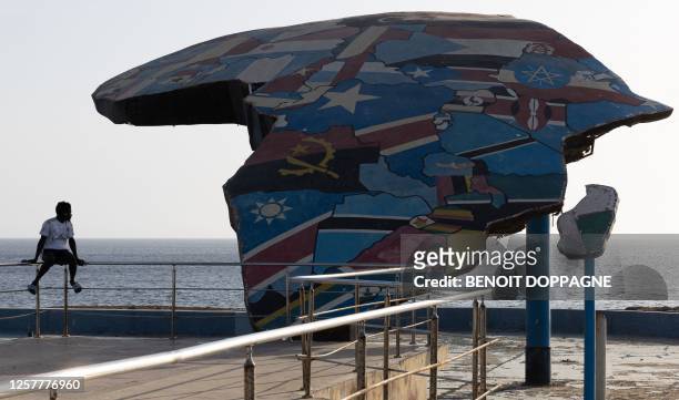 Child sits next to monument on the Place Du Souvenir Africain in Dakar, on the first day of an economic mission to the republic of Senegal, in Dakar,...