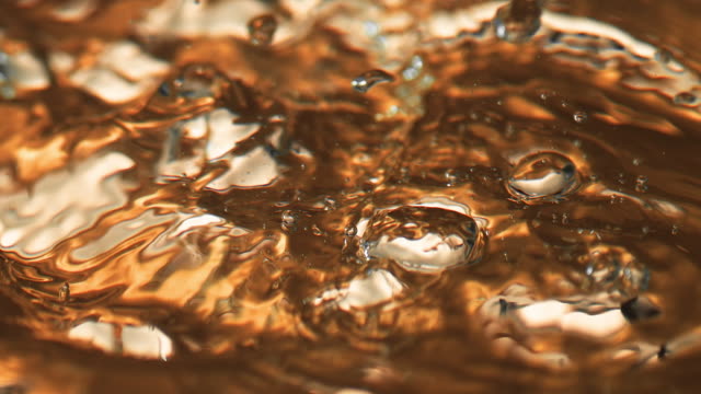 Liquid gold in dramatic close-up in slow motion