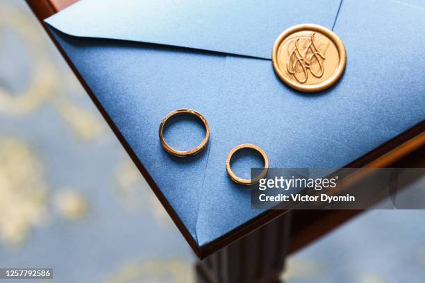golden wedding rings on the luxurious envelope - wedding ceremony stock pictures, royalty-free photos & images