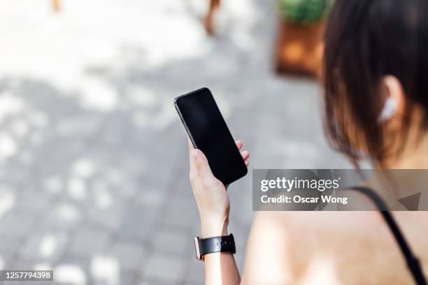 woman checking her mobile phone before exercising - look back ストックフォトと画像