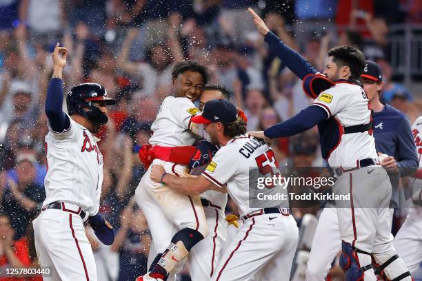 Ozzie Albies of the Atlanta Braves celebrates with teammates after his sacrifice fly gave the Braves a 4-3 victory against the Los Angeles Dodgers...