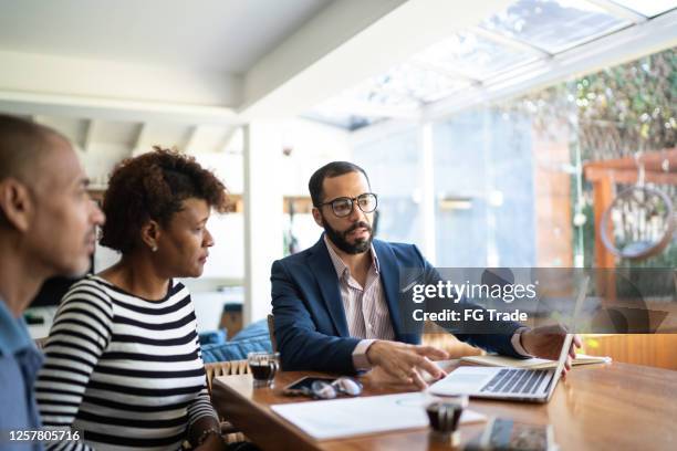 pareja hablando con asesor financiero en casa - customer fotografías e imágenes de stock