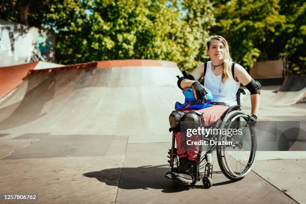 disabled woman in wheelchair doing stunts in skate park - disabled extreme sports stock pictures, royalty-free photos & images