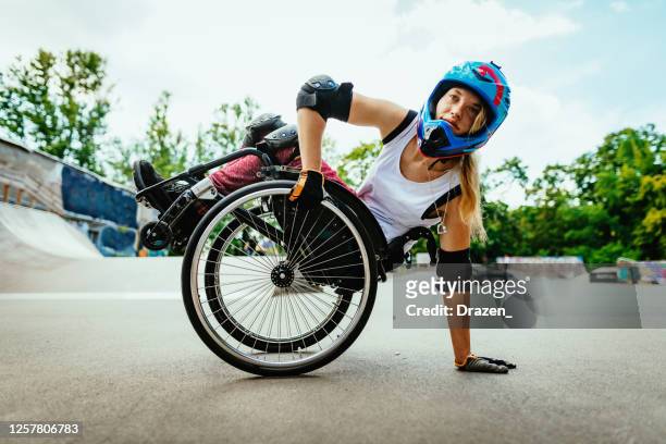 behinderte frau im rollstuhl macht stunts in skatepark nach sperrung - wheelchair stock-fotos und bilder
