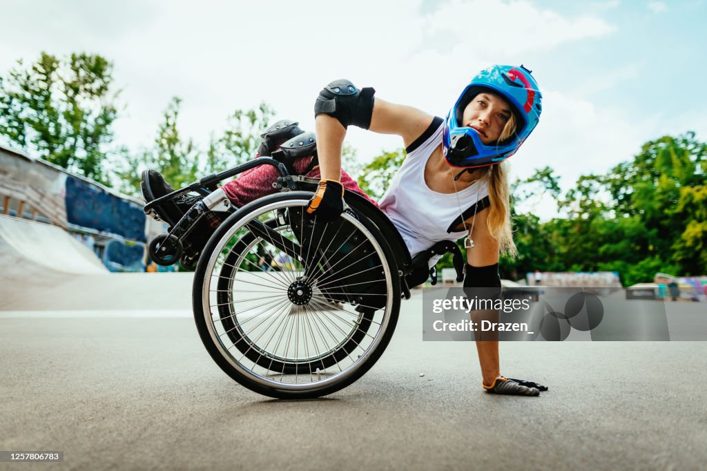 Disabled woman in wheelchair doing stunts in skate park after lockdown