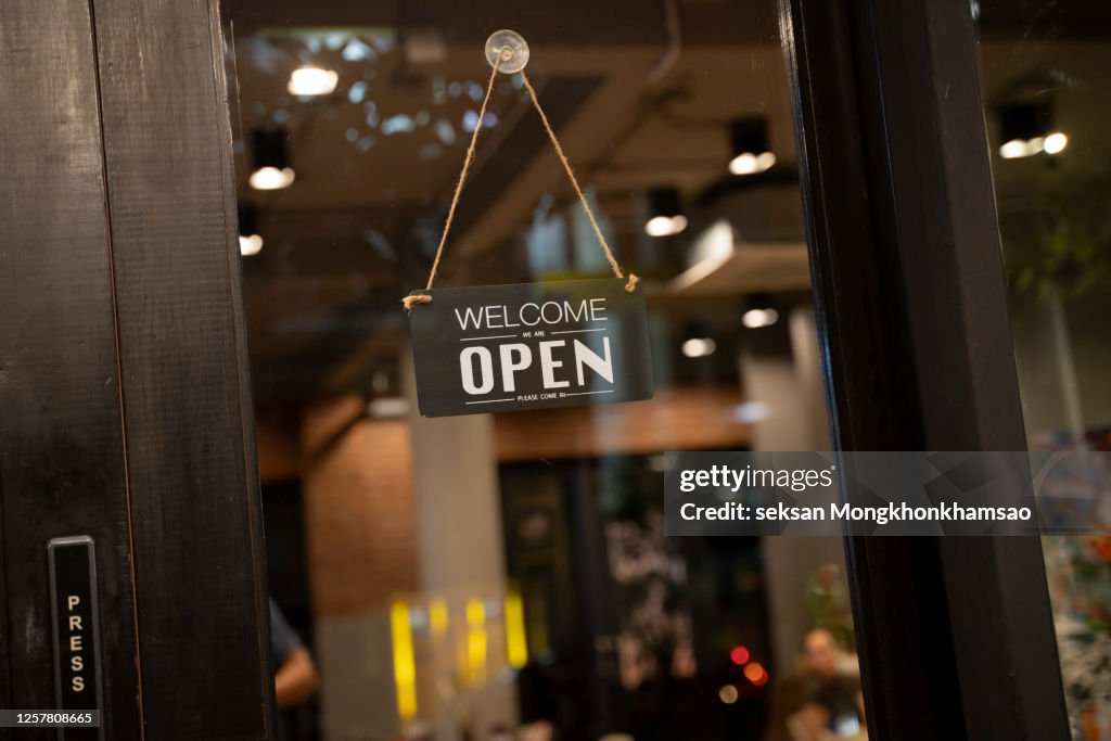 Open sign on cafe hang on door at entrance.