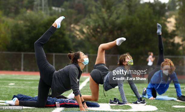 Olympic synchronized swimmer Anita Alvarez stretches with her team during a dry land training session on July 15, 2020 in Moraga, United States. The...
