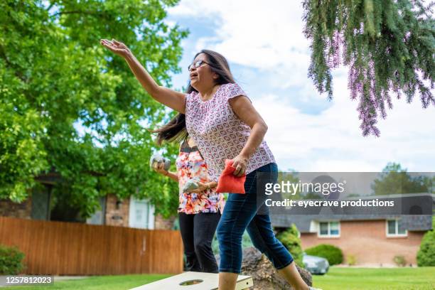 two adult senior female friends having fun together outdoors - corn hole stock pictures, royalty-free photos & images