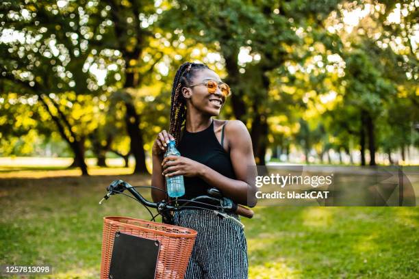 woman on a bike drinking water - cat drinking water stock pictures, royalty-free photos & images