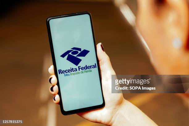 In this photo illustration, the Meu Imposto de Renda logo is displayed on a smartphone screen.