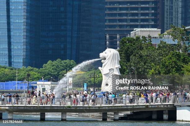 People gather next to the Merlion Statue at Marina Bay in Singapore on May 25, 2023.