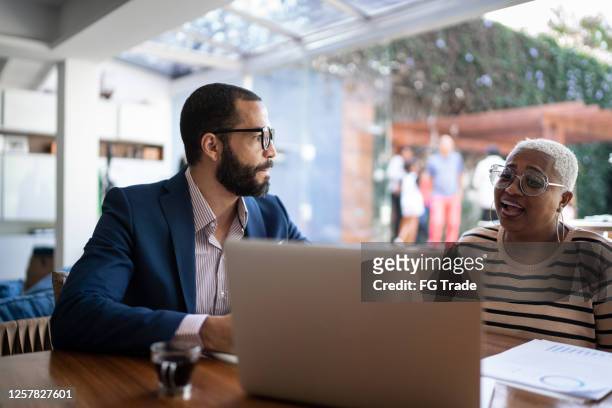 woman talking to finance advisor at home - two bank managers talking stock pictures, royalty-free photos & images