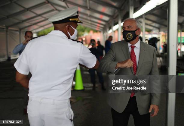 Vice Admiral Jerome Adams, the U.S. Surgeon General, greets Miami-Dade County Mayor Carlos Gimenez with an elbow bump as he toured the new federally...