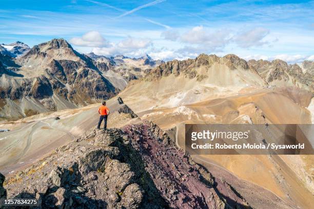 man standing on piz nair looks at mountains, switzerland - engadin stock pictures, royalty-free photos & images