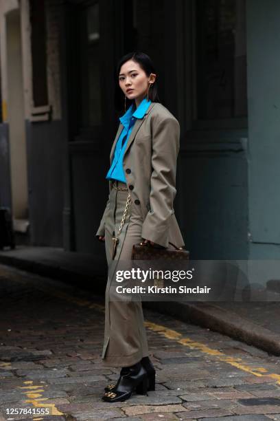 Digital influencer Freya Sinyu Siu wears Balenciaga boots, Louis Vuitton bag, Delada suit, Jenn Lee earrings and Mikio Sakabe shirt during London...