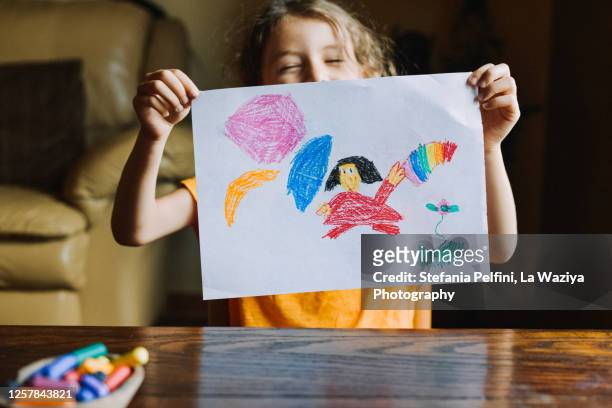 little girl showing her drawing - kid holding crayons stockfoto's en -beelden