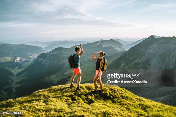 los corredores de trail ascienden a la alta cresta de la montaña - red tour fotografías e imágenes de stock