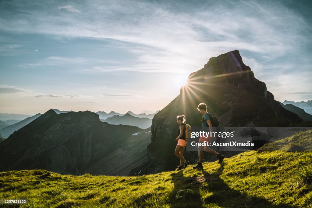 Trail runners ascend high mountain ridge