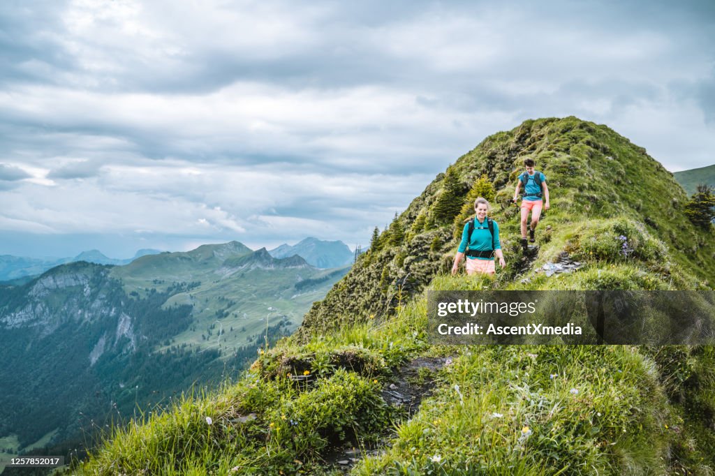 Trail runners ascend high mountain ridge