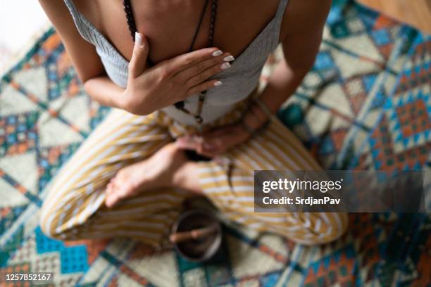 close-up of a woman's hand on her chest while doing breathing exercises - breathing exercise stock pictures, royalty-free photos & images