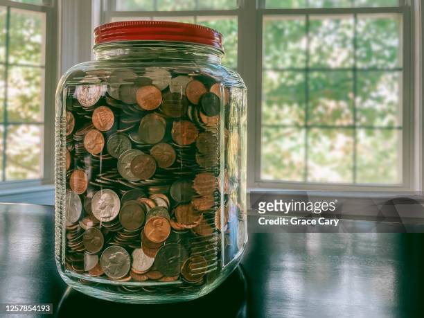 glass jar filled with us coins - five cent coin stock pictures, royalty-free photos & images