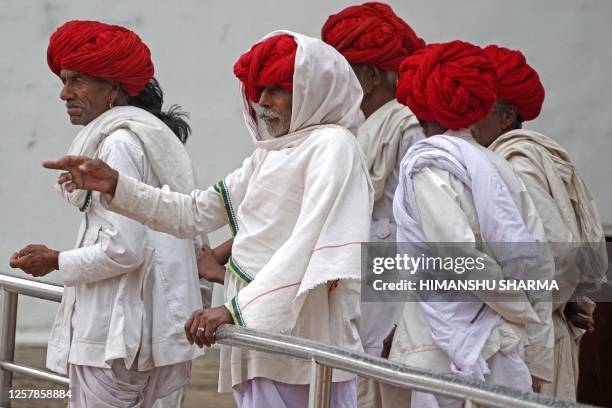 Local tourists stand by the holy lake as it drizzles in Pushkar, in India's desert state of Rajasthan on May 25, 2023.