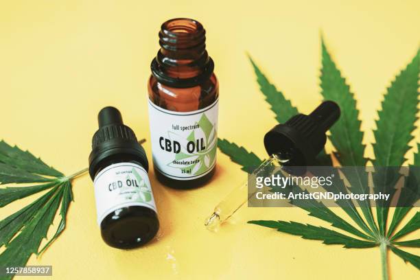 cbd-öl, cannabisöl auf gelbem hintergrund. - cannabidiol stock-fotos und bilder