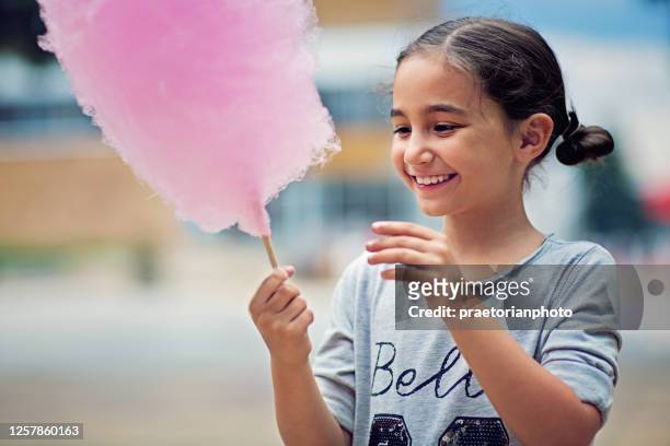 portrait of little girl eating cotton candy - cotton candy stock pictures, royalty-free photos & images