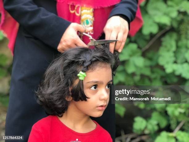 mother is cutting daughter’s hair at home - iran coronavirus stock pictures, royalty-free photos & images