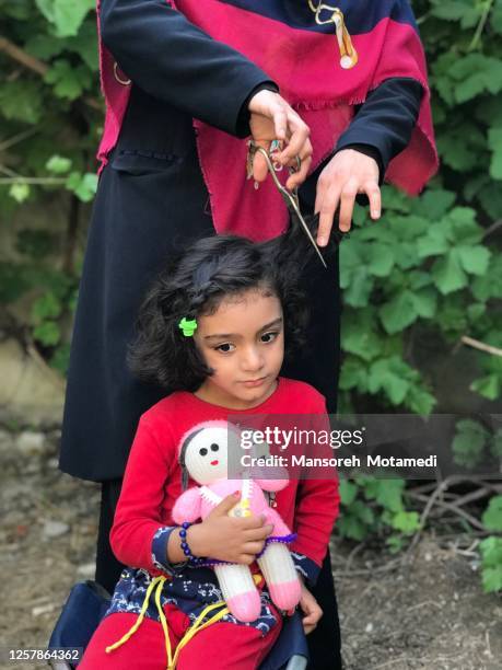 mother is cutting daughter’s hair at home - iran coronavirus stock pictures, royalty-free photos & images