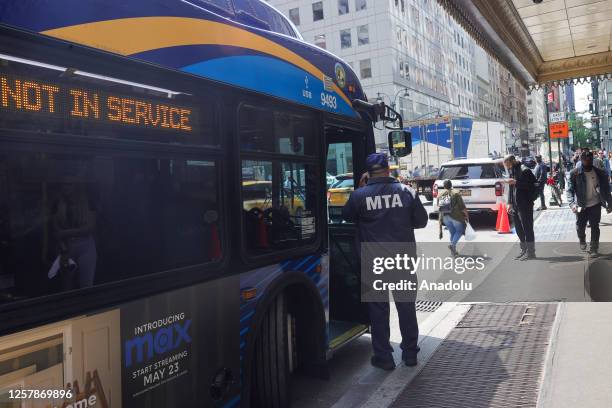 Bus waits to relocate immigrants in front of New York's iconic Roosevelt Hotel in midtown Manhattan which reopens as shelter for asylum seekers in...