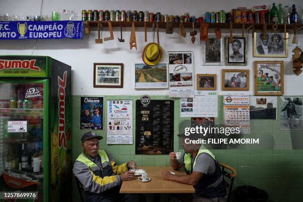 Men have their breakfast at a cafe in Algoz, a town near the Arade dam in Silves on May 25 on the third day of new search operations amid the...