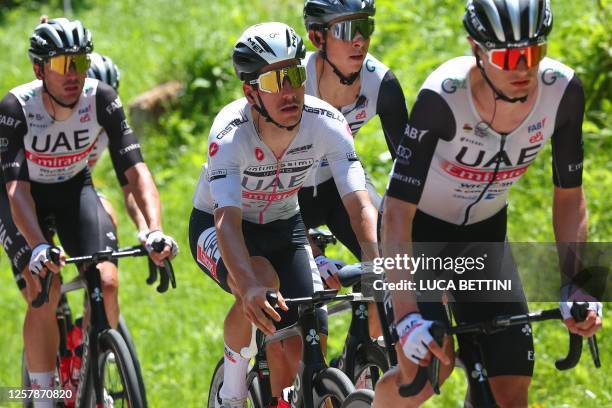 Best young rider's white jersey, UAE Team Emirates's Portuguese rider Joao Almeida rides with teammates in the pack during the eighteenth stage of...