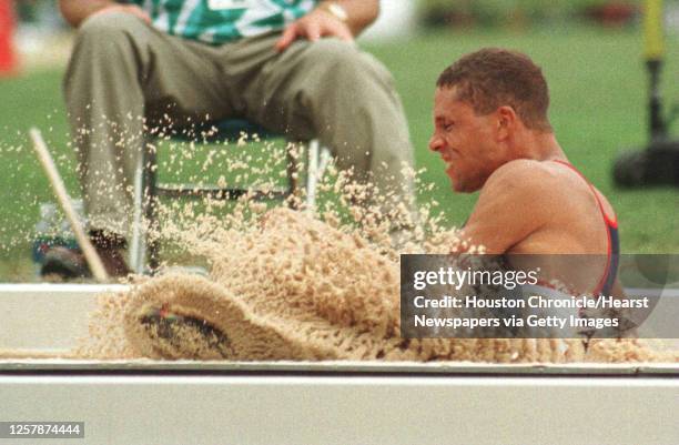 Dan O'Brien kicks up some sand during competition in the decathlon long jump 7/31. 1996 SUMMER OLYMPICS