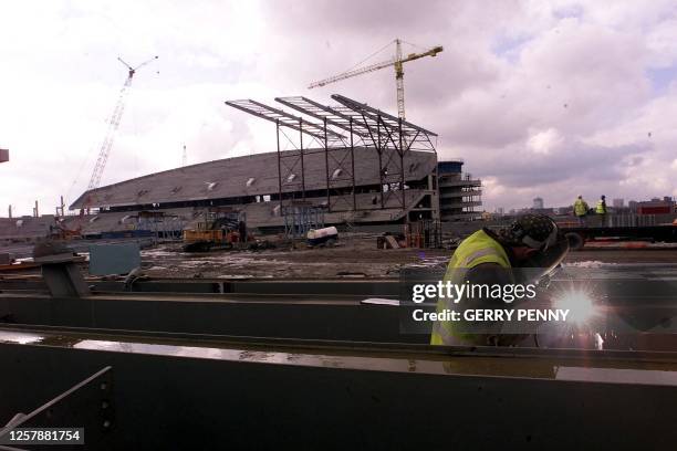Welder at work to supports of the new Manchester Stadium 14 March 2001, with the West Stand in background. Work started on the stadium in December...