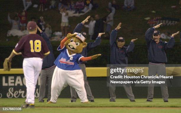 Bellaire third baseman Benjamin Silberman watches as the Little League mascot 'Dugout' does the 'YMCA' with umpires during a changeover between...