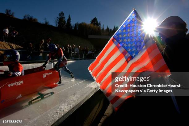 Behind the Stars and Stripes, Todd Hays, front, of Del Rio, and Pavle Jovanovic push from the start during US Bobsled National Team Trials at Utah...