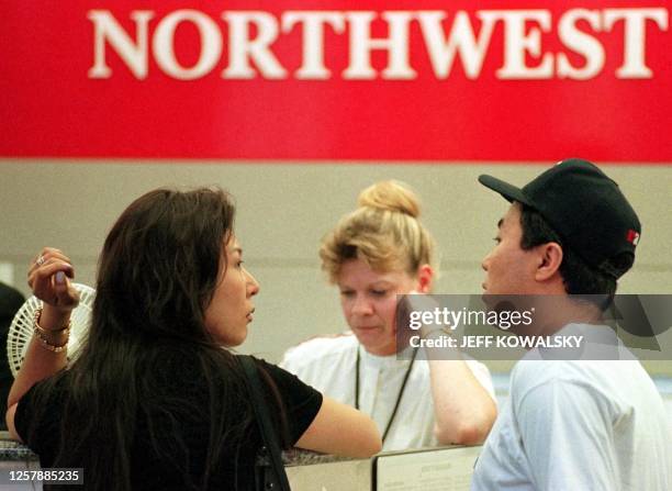 Myung Kim and Byoungc Yoon try to get to Las Vegas with the help of Northwest ticket agent Rita Liegl after their Northwest Airlines flight was...