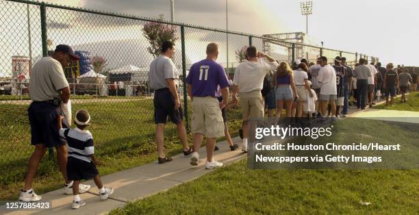 Long line of fans wait to enter the Houston Texans training facility for the first public practice of the team's inaugural training camp, Monday...