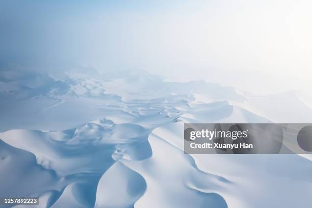 aerial view of snow covered desert sand dunes - mountains pov stock-fotos und bilder