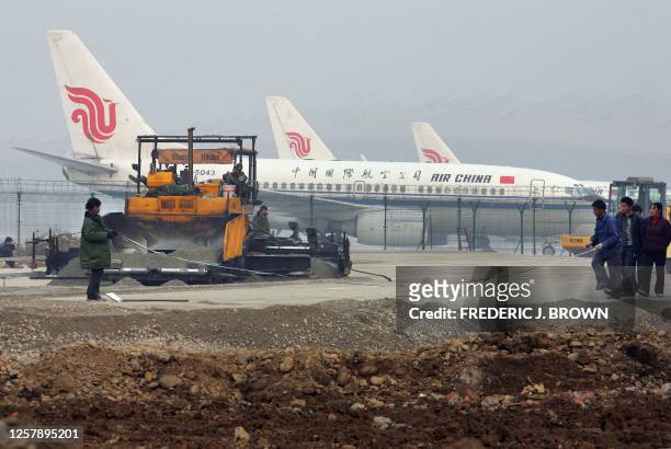 Air China airplanes sit on the tarmac in front of the new third terminal at Beijing's international airport, 05 November 2007, while workers help...