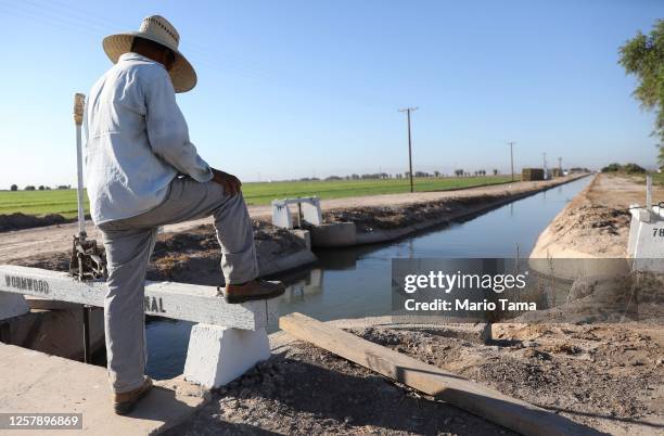 Adolfo, a documented migrant day laborer who lives in Mexico, works irrigating an alfalfa field in Imperial County, which has been hard-hit by the...