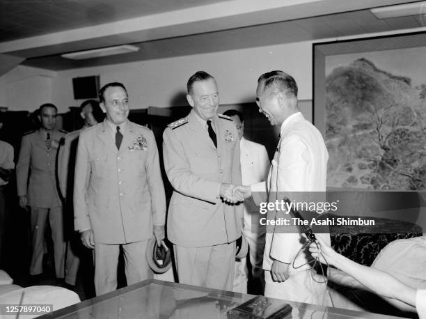 Chairman of the Joint Chiefs of Staff Arthur W. Radford shakes hands with Defense Agency chief Naka Funada while Commander of U.S. Army forces in the...