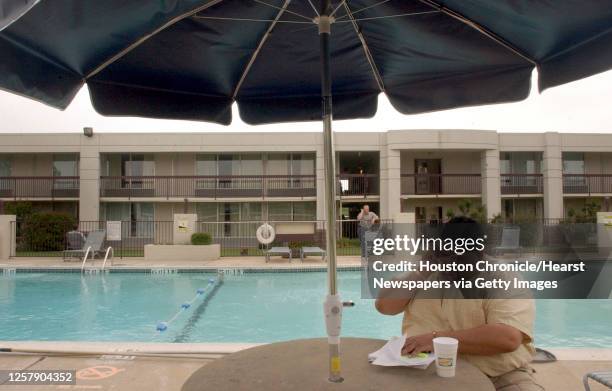 Rep. Joe Moreno of Houston makes a phone call from beside the pool at the Holiday Inn in Ardmore, OK, Tuesday afternoon, May 13, 2003. A group of 51...